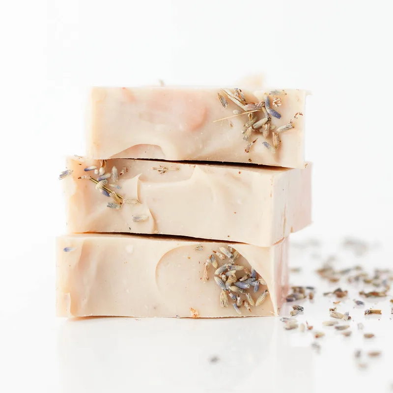 Stacked soaps with dried lavender buds. Featured scent: Cottage Garden